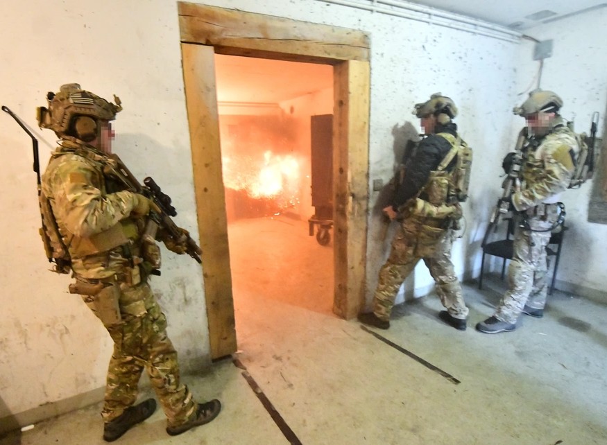Operators moving through a doorway lit by an interior breach