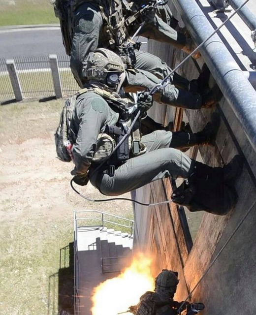 Operators rappelling from height with breach below