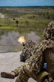 Sniper team firing on a range with muzzle flash
